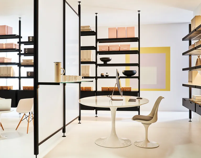 Black Sorbetti shelves are used to carry miscellaneous office boxes and decorations around an office space. Two white Sorbetti with white panels are used along the center to divide the room.