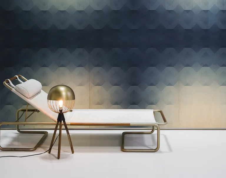 A white lounge chair is placed in front of a navy blue and circular tan patterned Veneer Panel wall.