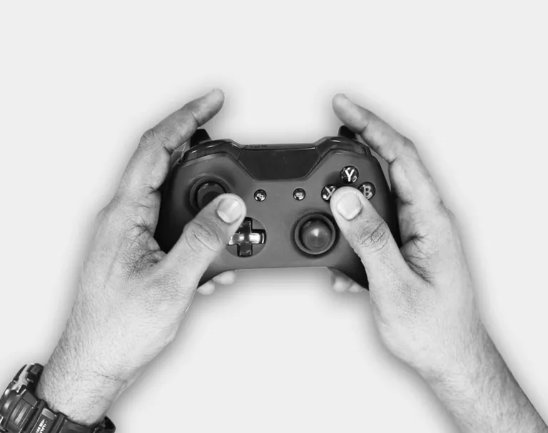 A hand holding and XBox controller