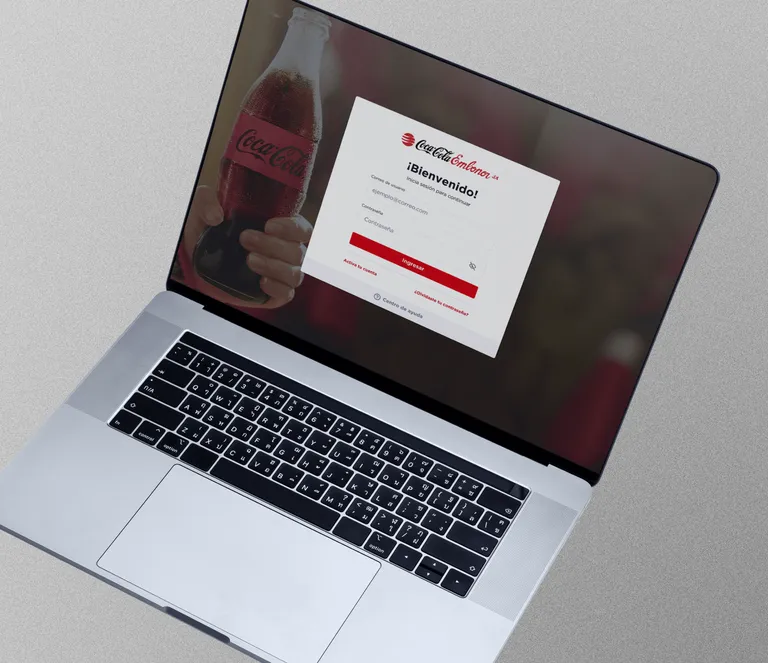 A laptop shows the Welcome Log-In page for Coca Cola Embonor