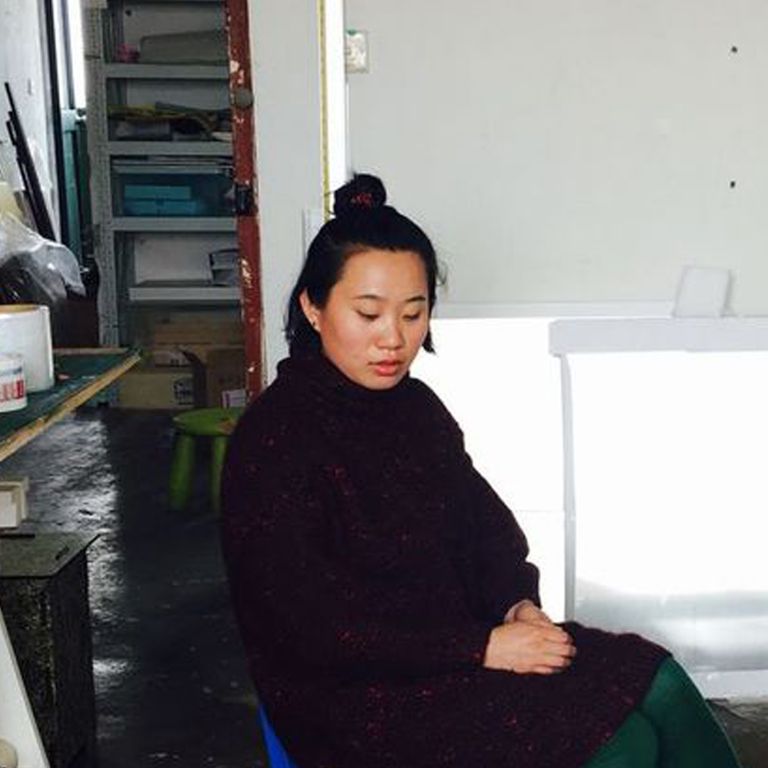 Artist Zhang Ruyi sitting in the studio
