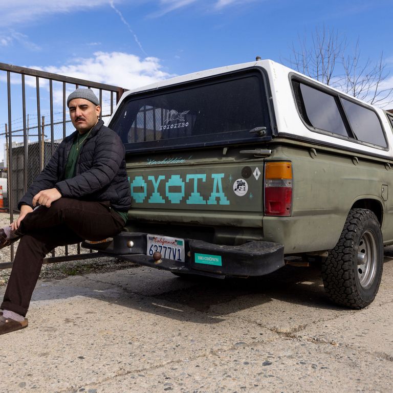 artist sitting on the back of a Toyota truck