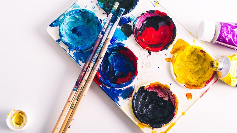 Aged care activities- Photo of a white plastic paint palette with blue, red and yellow paints and three paint brushes