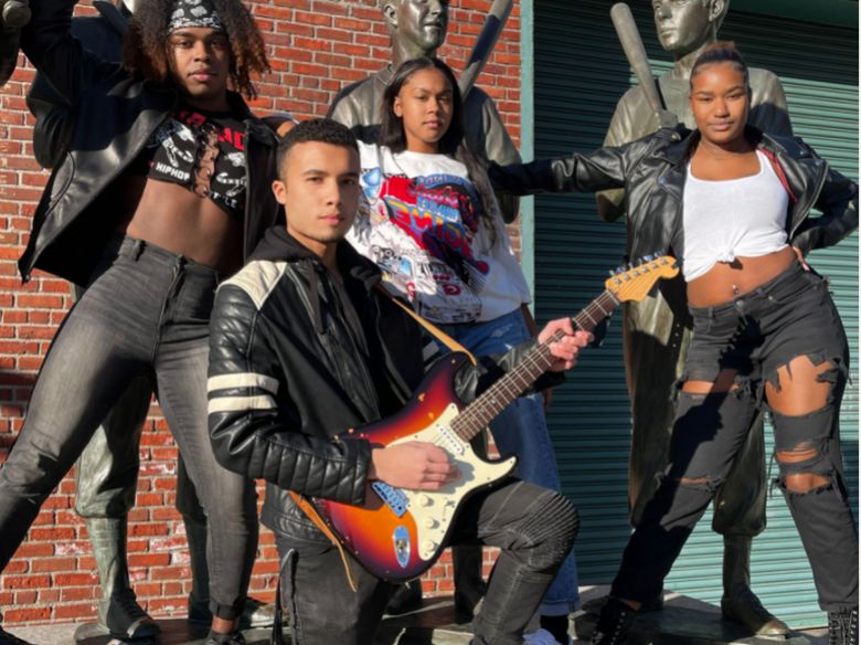 students posing in rock attire, holding a guitar