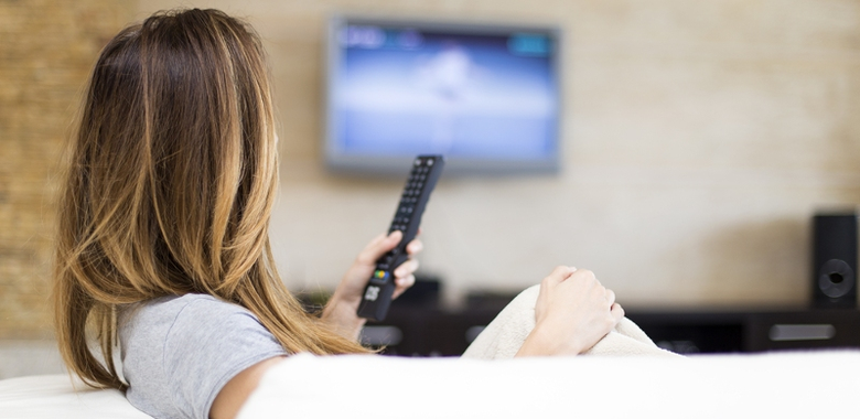 Žena s ovladačem sleduje internetovou televizi