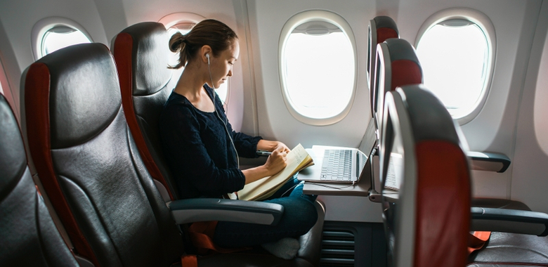 Žena se sluchátky sedí v letadle