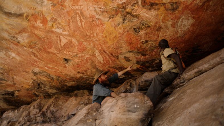 Two men viewing rock-art in arnhemland