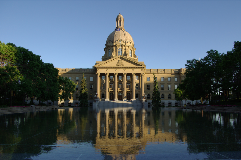 The Legislative building in Edmonton reflected in a pond on a summer's day.