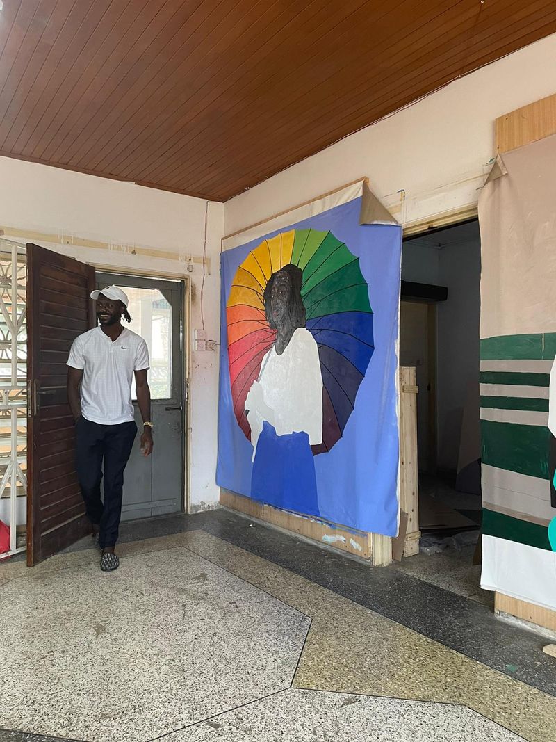 Amoako Boafo walking by a large painting in his studio
