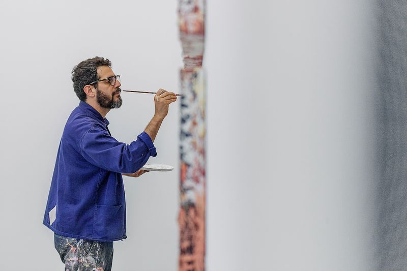 Portrait of an artist Jose Parla paining at his studio
