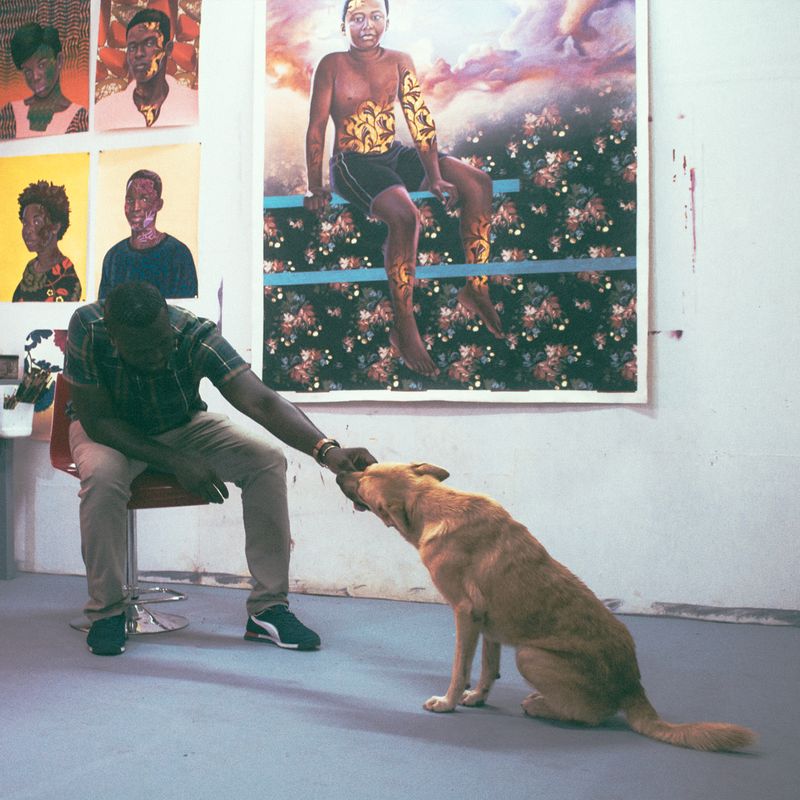 Patrick Quarm saying hello to a dog in his studio