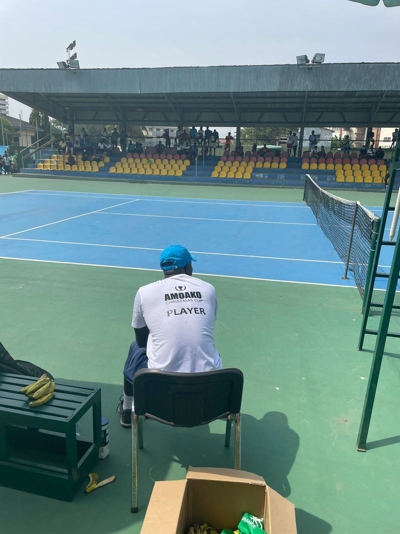 Amoako Boafo sat on a tennis court