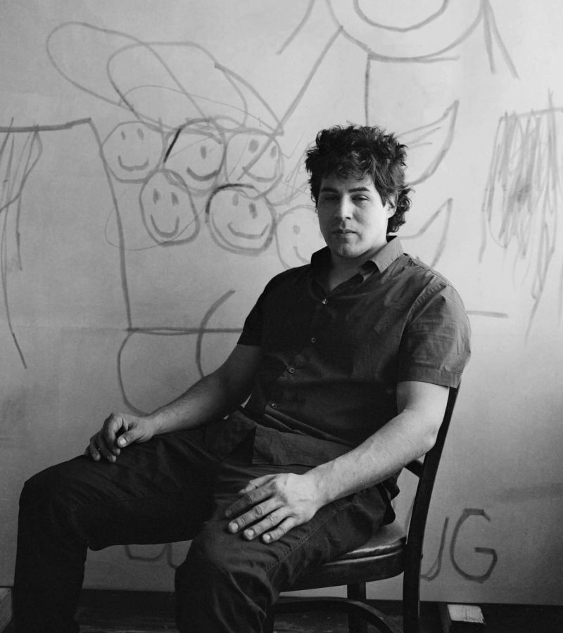 Artist Robert Nava sits on a chair