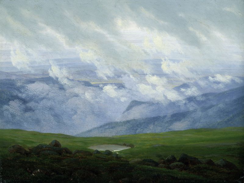 Drifting clouds over green mountainous landscape