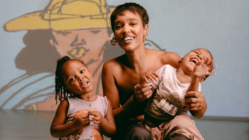 mother and her two children, smiling in front of a projected artwork
