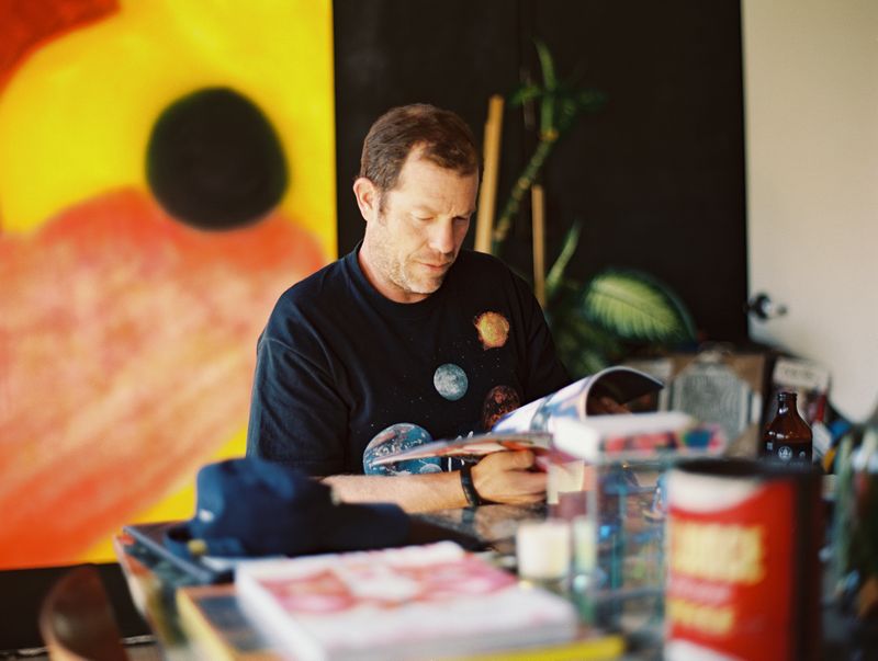 A close up shot of Darren Romanalli sitting in his studio and looking through a book