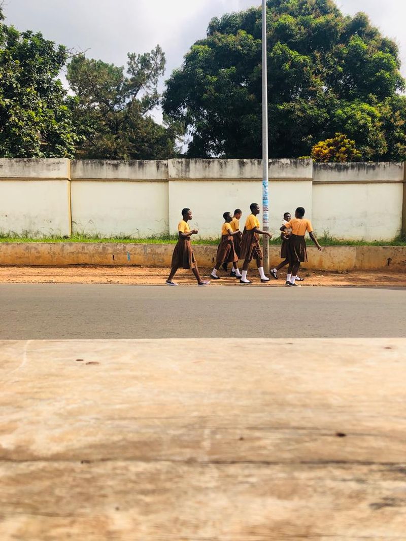 school children walking by the side of a road
