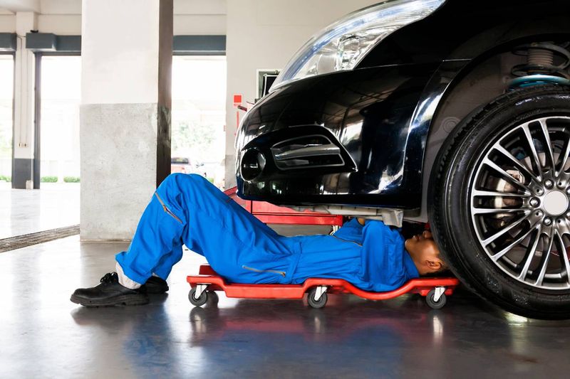 Jak vybrat olej do auta - Mechanik na podložce pod autem