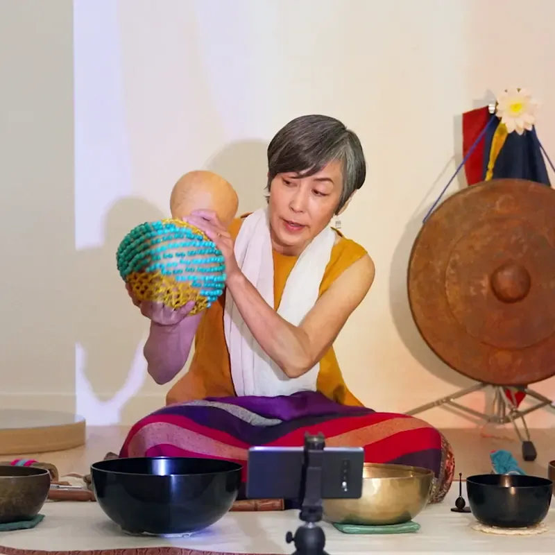 Woman recording herself playing a cabasa on her phone, from the MassiveMusic TikTok campaign