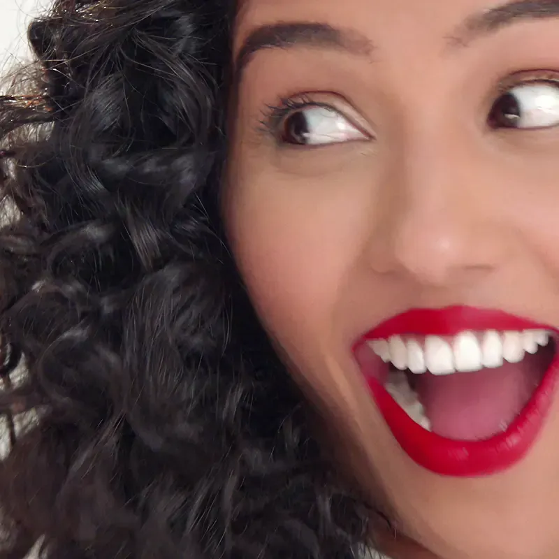 Woman smiling with bright white teeth, from the Sound of Colgate campaign