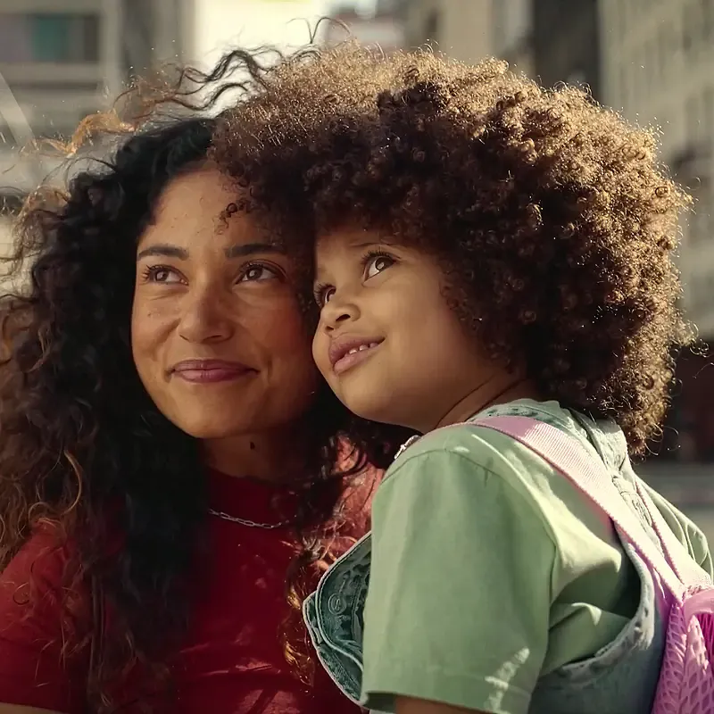 Mother carrying her daughter on a city street, square image from the MassiveMusic Dove The Code campaign
