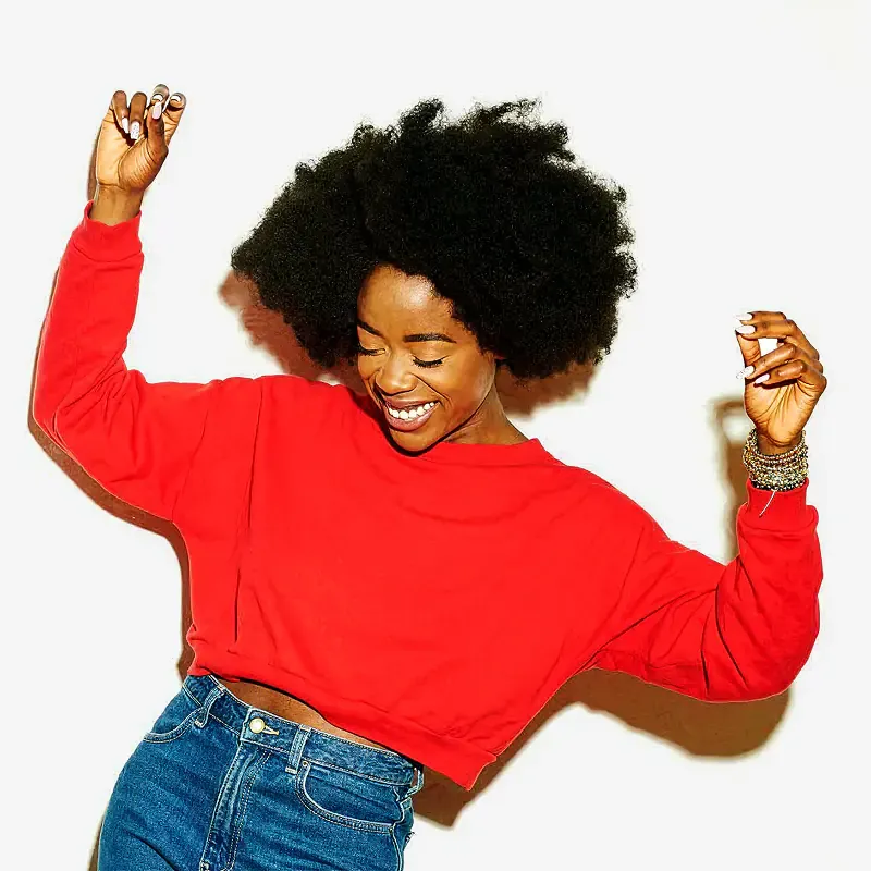 Woman in a red top dancing on white, square image from the Sound of Colgate campaign