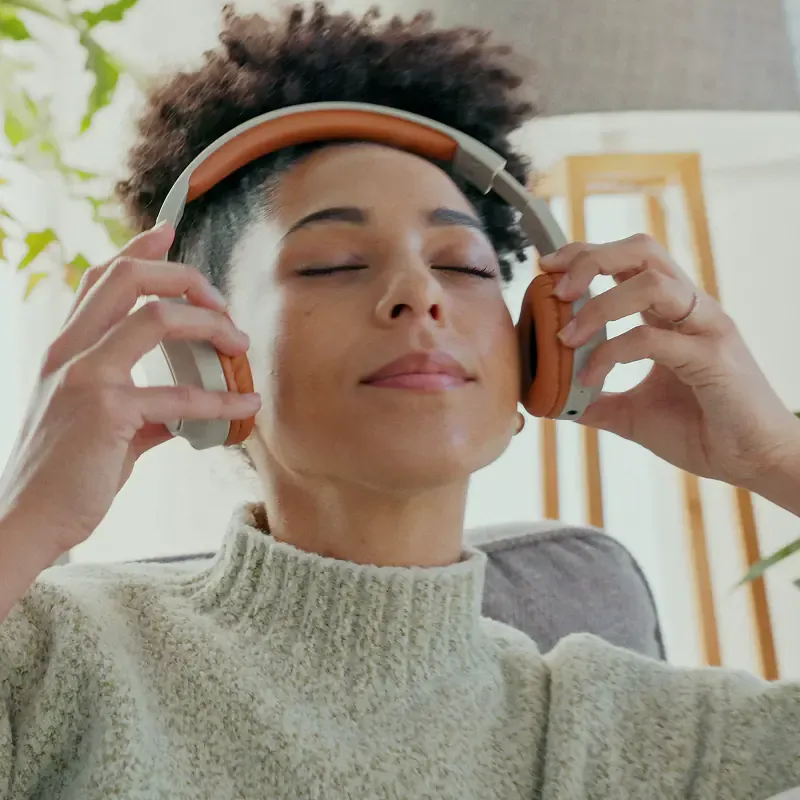 Woman wearing headphones with eyes closed, lost in music, from the MassiveMusic TikTok campaign