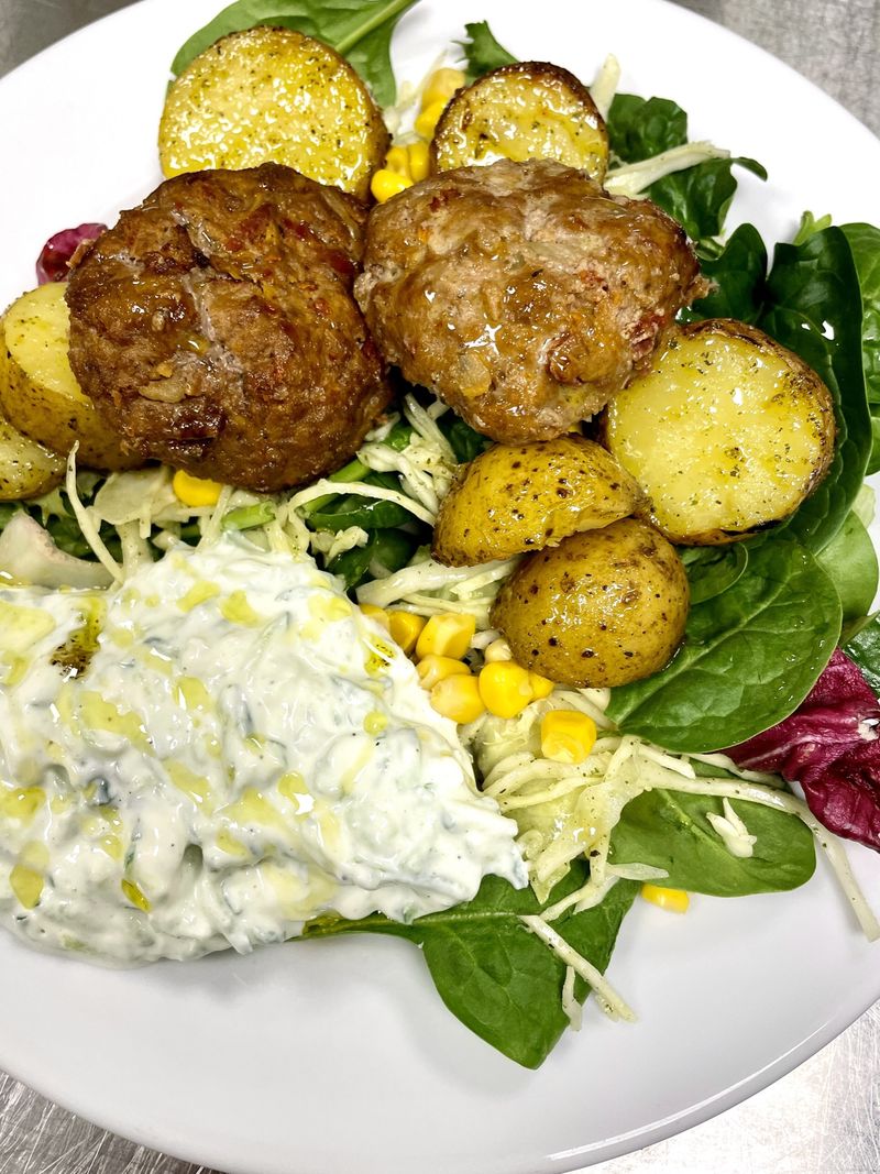 Klimatsmarta grekiska biffar serveras med tzatziki och örtrostad potatis