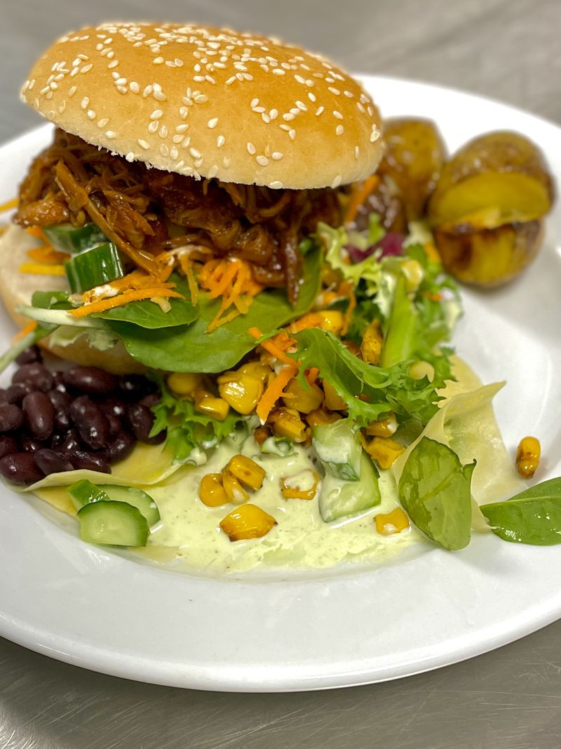 Pulled pork med svarta bönor och rostad majs i hamburgebröd.