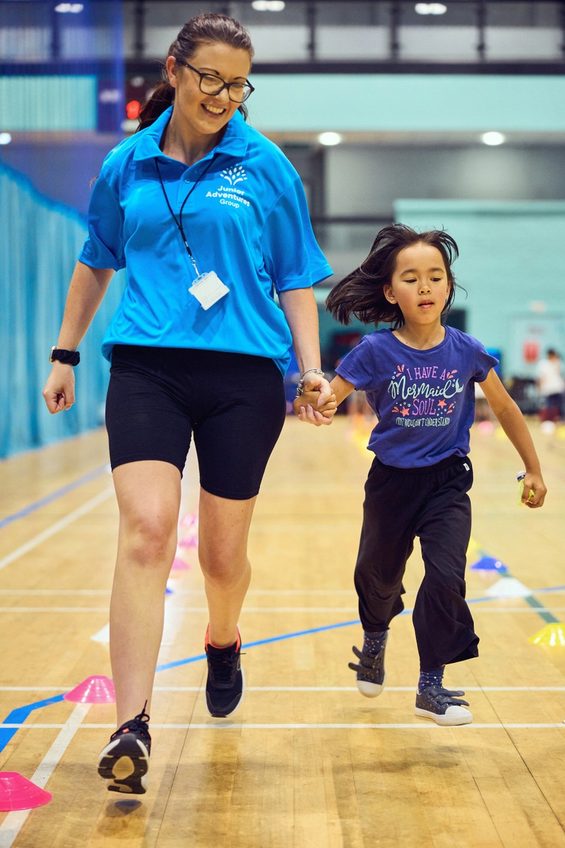 JAG Staff and Child running in a sports hall