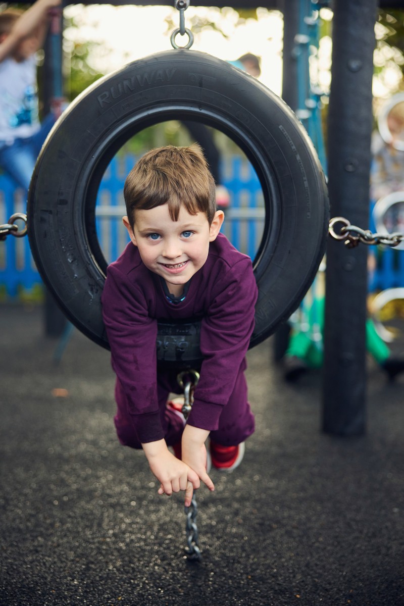 Child having fun on a tyre swing