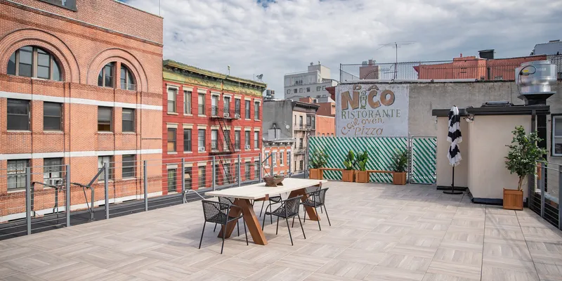 Nolita rooftop with chairs and tables and pizzeria in Little Italy