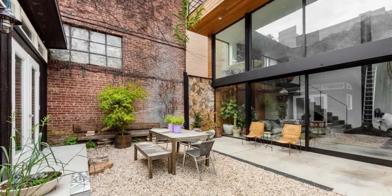 Garden in Brooklyn with loungechairs, wooden chairs and wooden table