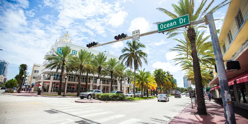 Ocean Drive in Miami with traffic lights and palm trees and cars
