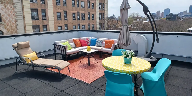 Rooftop in Brooklyn with couches and chairs overlooking New York skyline 