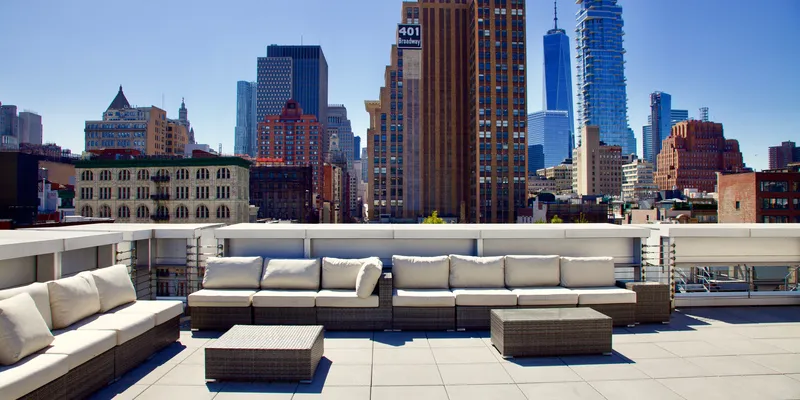 Manhattan rooftop with couches and tables overlooking NYC skyscrapers