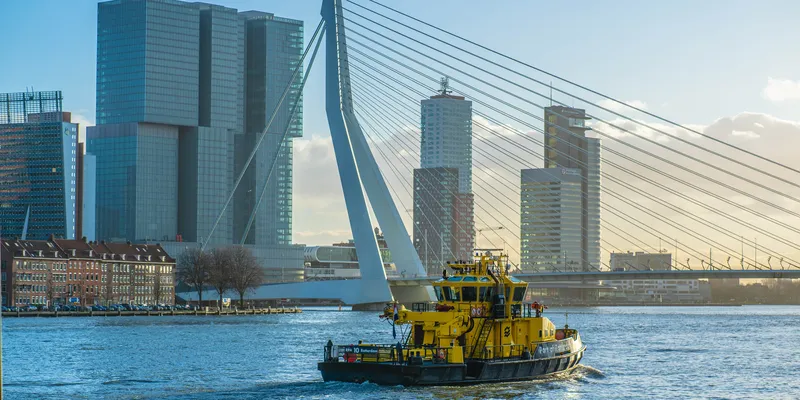 Rotterdam skyline with boat sailing on Maas river 