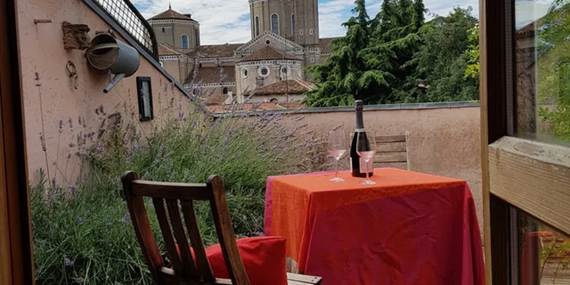 Private terrace in Padua with red cloth, bottle of wine and two glasses on table