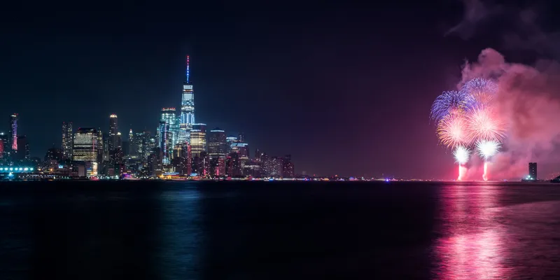 Red and purple fireworks with Manhattan skyline and Hudson river