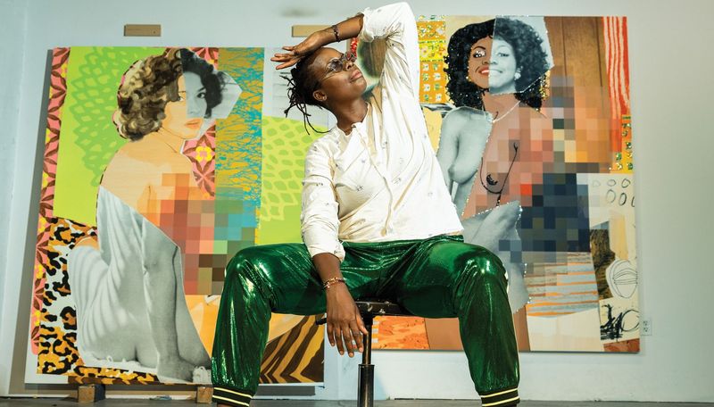 Mickalene Thomas sat on a stool in front of two paintings raising her hand to her head