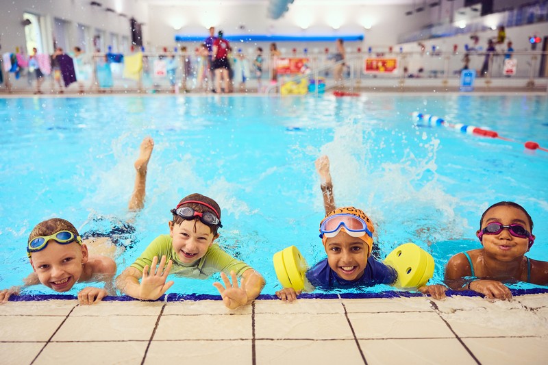 Group photo of children smiling in a swimming pool