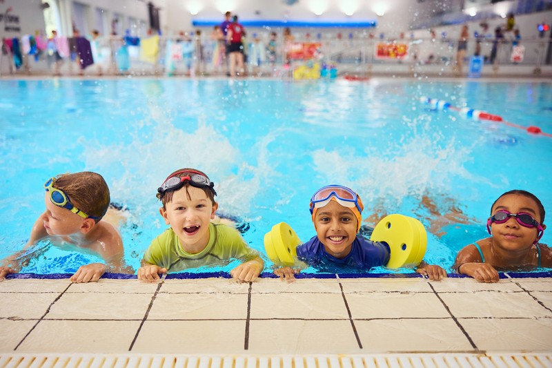 Group photo of children smiling in a swimming pool