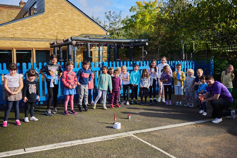 Children lining up outdoors for science rocket experiment