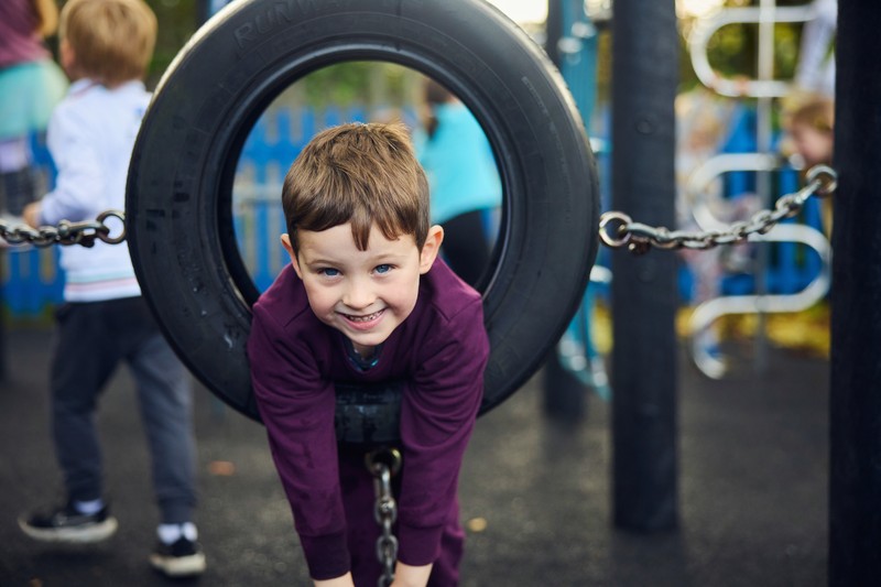 Child having fun on a tyre swing