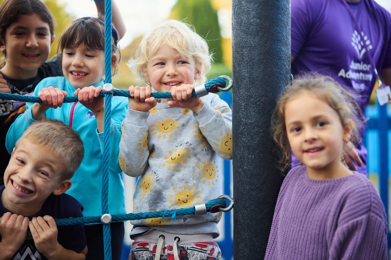 Group of children smiling on climbing frame