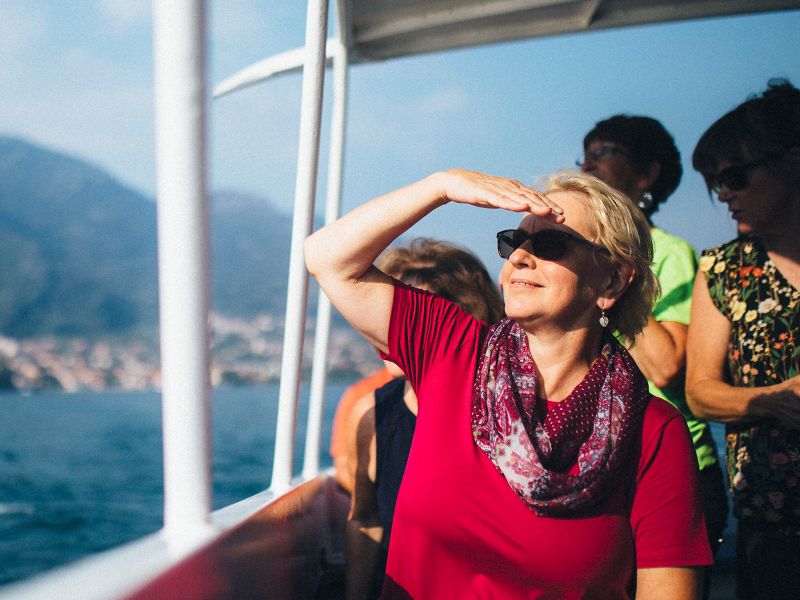 travelers take in the views of lake como italy by boat