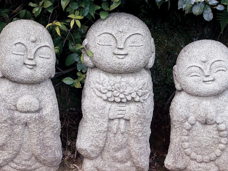three stone statues with happy expression