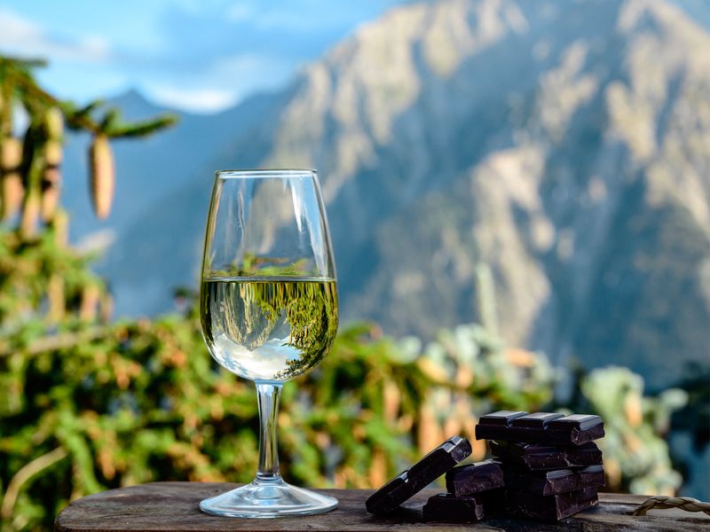 glass of white wine on table in the alps