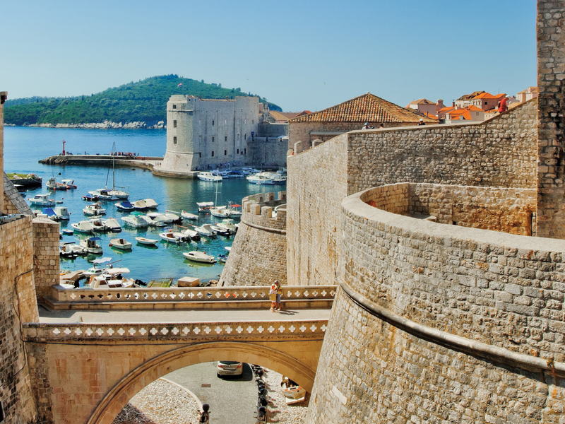 tan stone walls of dubrovnik with view of water
