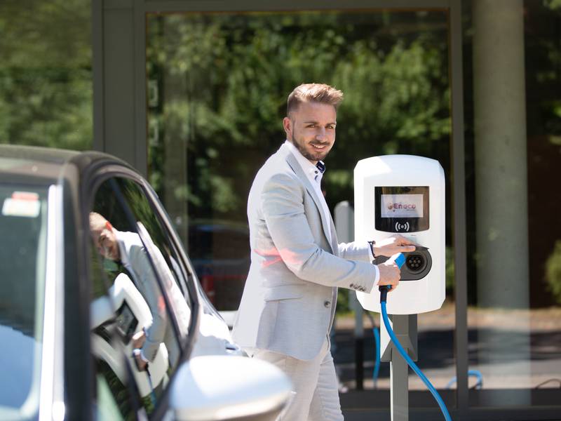 Man charging his e-car at work